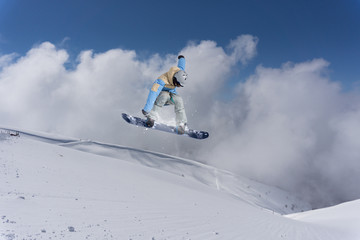 Naklejka na ściany i meble Snowboard jump on mountains. Extreme sport.