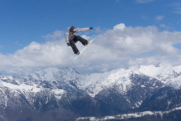 Naklejka na ściany i meble Snowboard jump on mountains. Extreme sport.