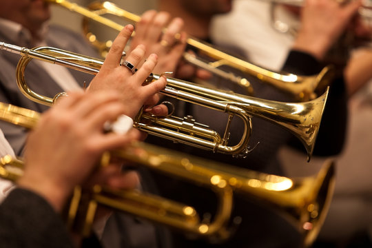 Trumpets in the hands of a musician in the orchestra closeup