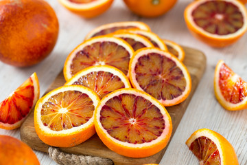 cut blood oranges on wooden surface