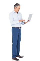 Smiling businessman typing on laptop