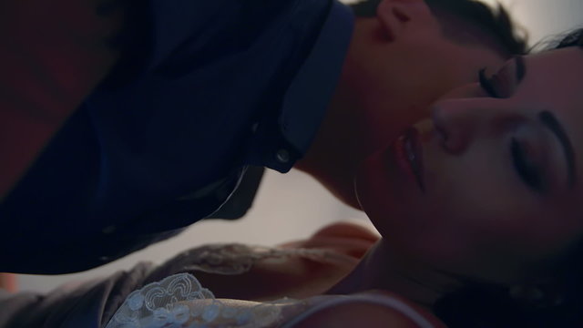 Young husband kisses his wife on her face and neck