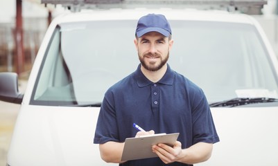 Delivery man writing on clipboard