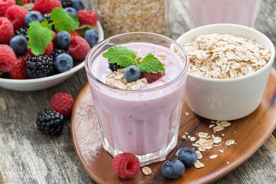 berry smoothie with oatmeal in a glass on wooden table, top view