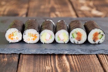 Homemade maki sushi rolls on a slate board