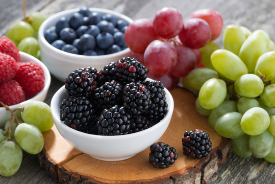 fresh berries and grapes on a wooden table