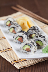 Uramaki sushi with avocado, raw salmon and black sesame