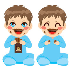 Baby boy eating chocolate bar with face dirty with funny chocolate mustache