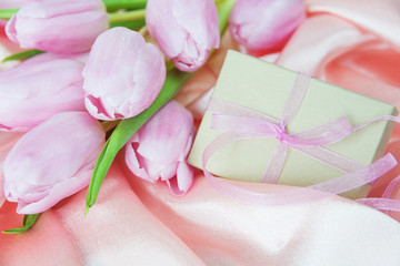 Obraz na płótnie Canvas Flowers and gift box on a silk fabric