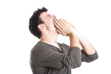 Young man shouting with hands on the mouth isolated on a white b