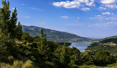Mountain landscape with a lake and some towns and a road, in Cáceres, Spain