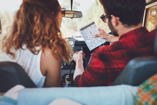 Young couple checking a map on roadtrip
