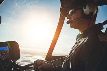 Pilot flying a helicopter on a sunny day - obrazy, fototapety, plakaty
