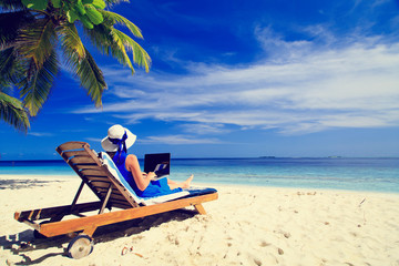 Fototapeta premium young woman with laptop on tropical beach