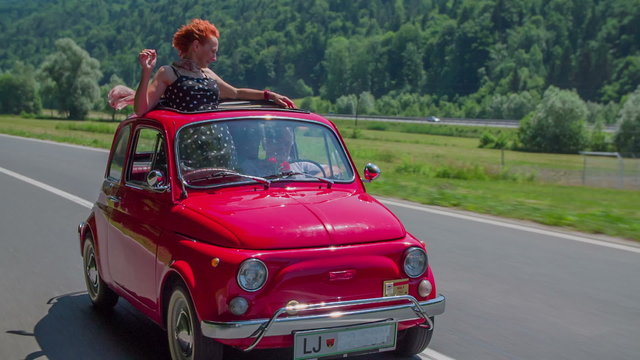 Senior lady enjoying the car ride in a red zastava