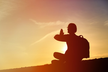 man doing yoga at sunset sky