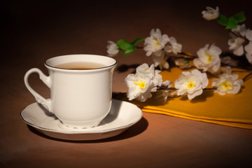 still life with cup of tea and cherry blossom