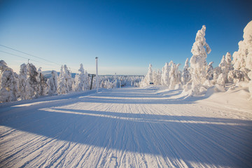 Beautiful cold mountain view of ski resort, sunny winter day with slope, piste and ski lift - obrazy, fototapety, plakaty