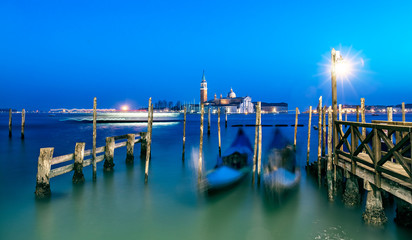 Venice blue laguna with blurred gondolas at night