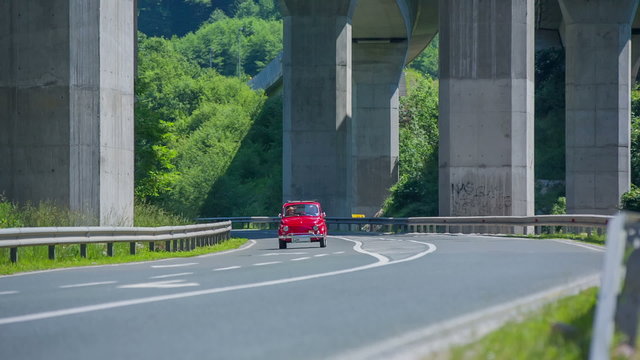 Older couple driving under a viaduct