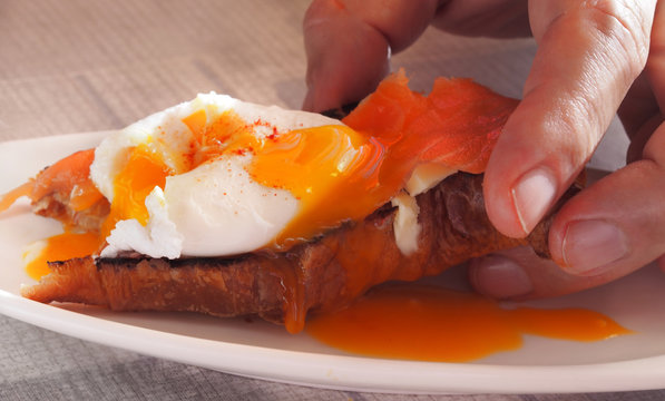 Breakfast of croissants with salmon, poached egg on a white plate