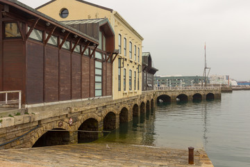 Naklejka premium Old arches of stone at the port of Gijon, Spain