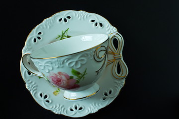 White tea cup and saucer on a black background