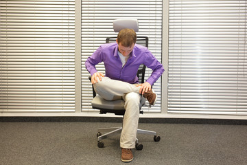 man exercising on chair in office, healthy lifestyle - front 