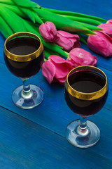 two glasses of red wine and tulips