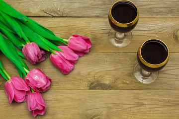 Fototapeta na wymiar two glasses of red wine and tulips
