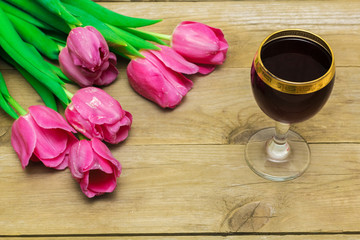 Fototapeta na wymiar glass with red wine and tulips