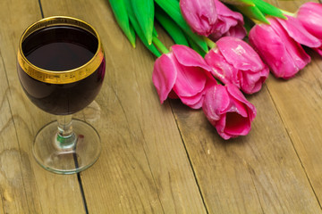 Obraz na płótnie Canvas glass with red wine and tulips