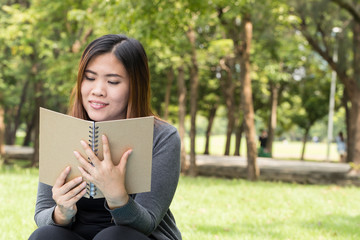 Fototapeta premium Asian woman reading a book in the park
