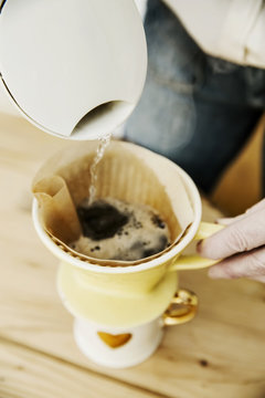 Frau kocht eine Tasse Kaffee,