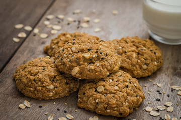 Oatmeal cookies with sesame seeds and glass of milk