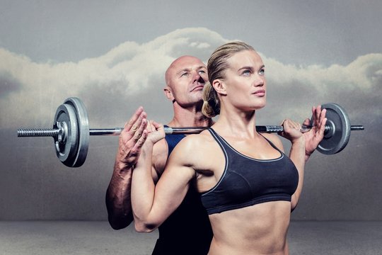 Composite image of trainer helping woman for lifting crossfit