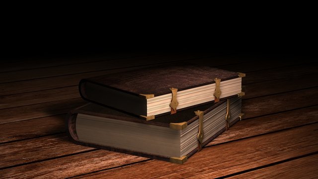 two old leather books with metal claps on wooden table 