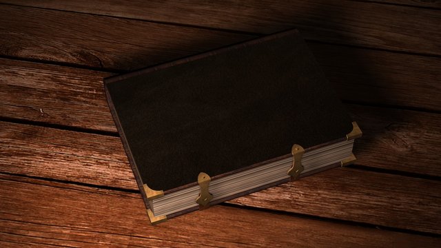 Old leather book on wooden table in candlelight