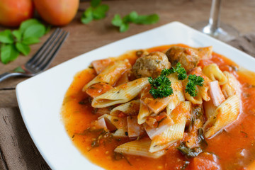 Penne pasta with meatballs in tomato sauce