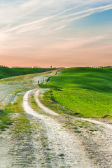  Long and winding rural road crosses the hills at sunset