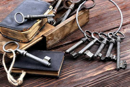 Old metal keys and vintage book on a wooden table
