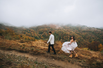 Fototapeta premium happy newly married couple posing in the mountains