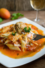 Penne pasta with meatballs in tomato sauce