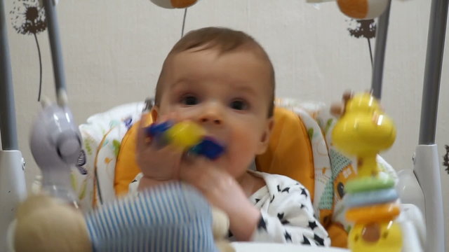 seven-month baby playing automatic electric swing
