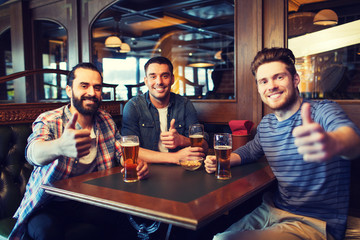 happy male friends drinking beer at bar or pub