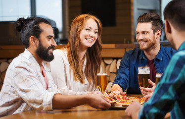 friends eating pizza with beer at restaurant