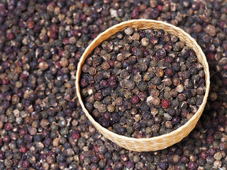 Black peppercorn background. Dried black pepper in weave bowl. Pepper seed.