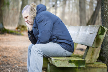 Depressed man in the park on bench