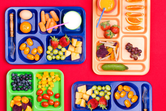 Four trays filled with fruit and vegetables