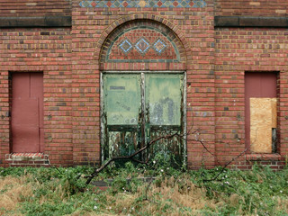 Industrial grungy double doors on abandoned brick building - landscape color photo